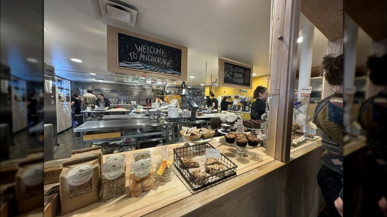 Bakery counter with "Welcome to Anchorage" sign in background