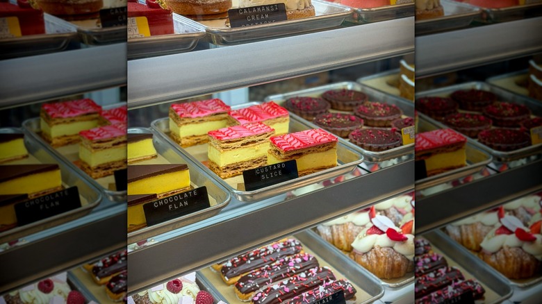 Various pastries on display in glass-fronted bakery counter