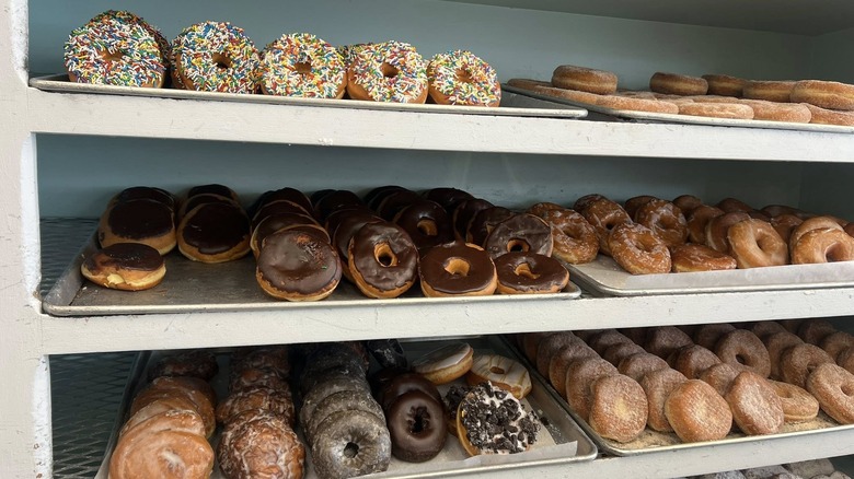 Various glazed ring donuts on bakery shelves
