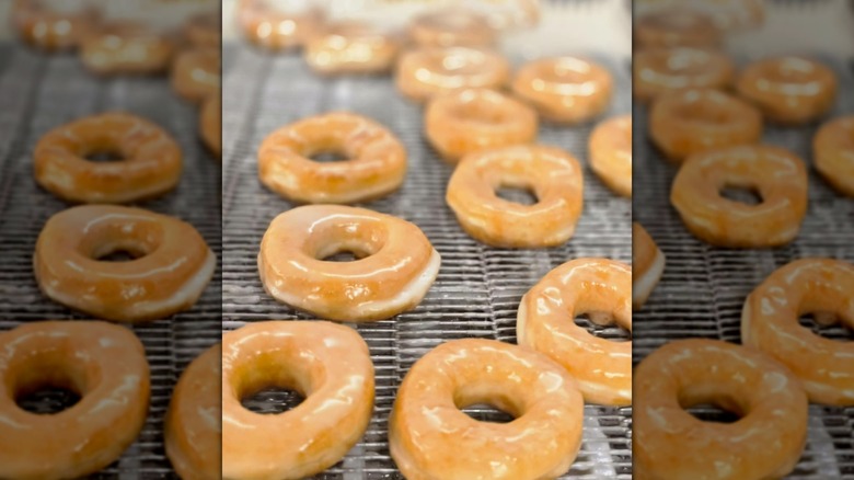 Glazed ring donuts on metal rack