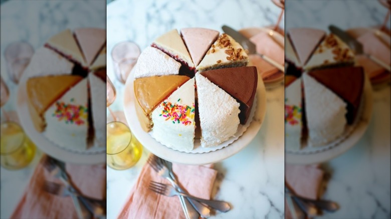 Various flavors of cake sliced and displayed on cake stand
