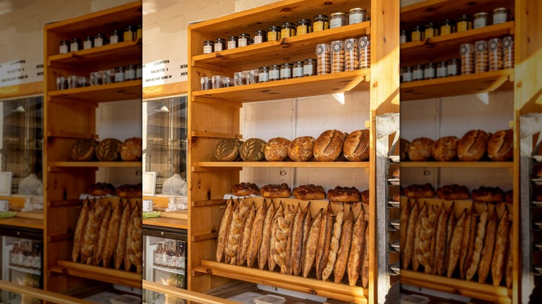 Freshly baked breads on display on wooden shelves in bakery