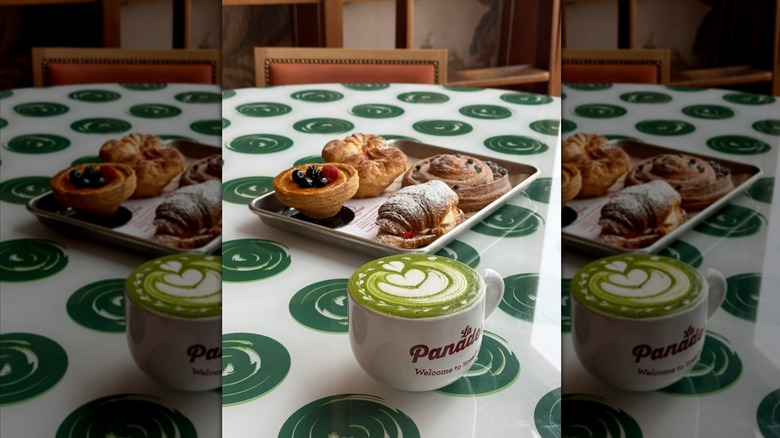 Mug of matcha and tray of pastries on table