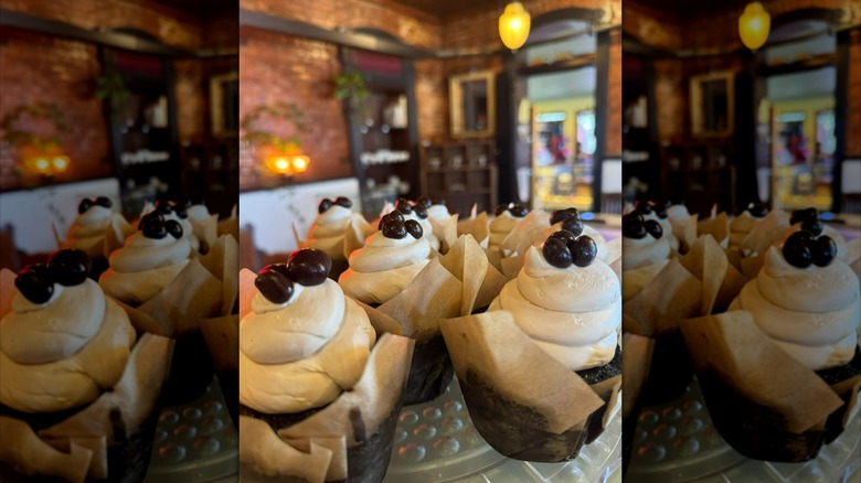 Espresso cupcakes in parchment wrappers, displayed on bakery table