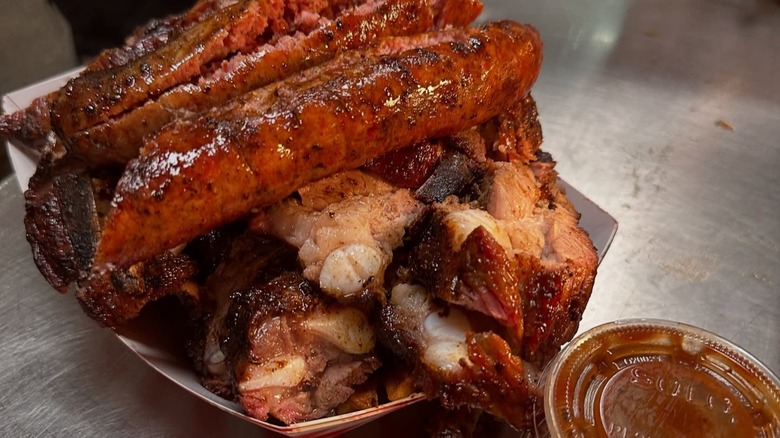 Cardboard tray with hot links and ribs with container of BBQ sauce at Lem's Bar-B-Q