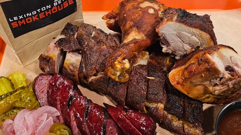 Platter of assorted smoked meats including sausages, chicken, and pickled veg served at Lexington Betty Smokehouse