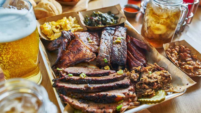 Platter of BBQ meats with beer, tea, and sides