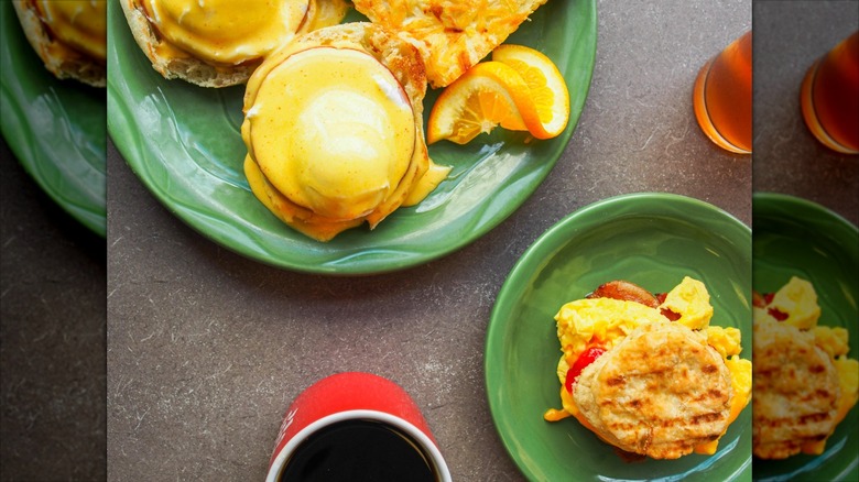 Plates with biscuit breakfast sandwich and eggs Benedict
