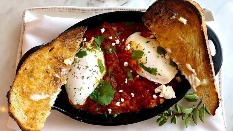 Shakshuka with toast in a cast iron serving pan