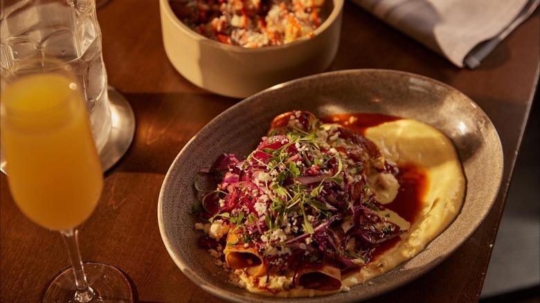 Brunch dish on rustic table with mimosa