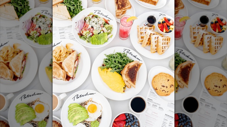 Assortment of brunch dishes and drinks with menus on white tablecloth