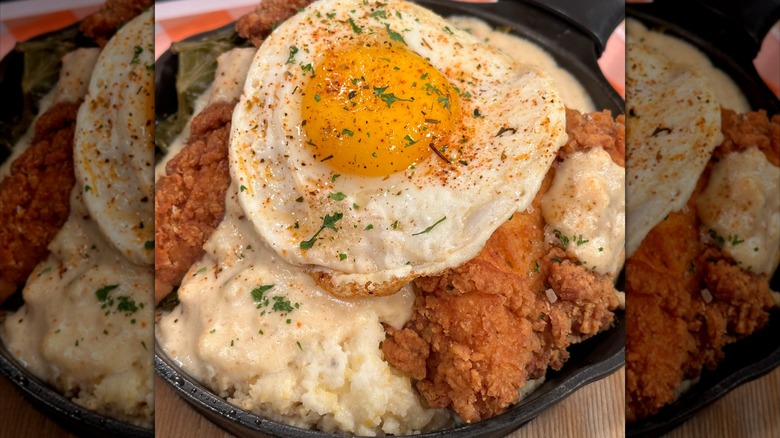 Skillet with fried chicken, mashed potato, and egg on top
