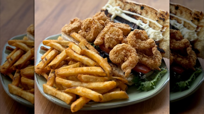 Plate of fries and fried shrimp on wooden table