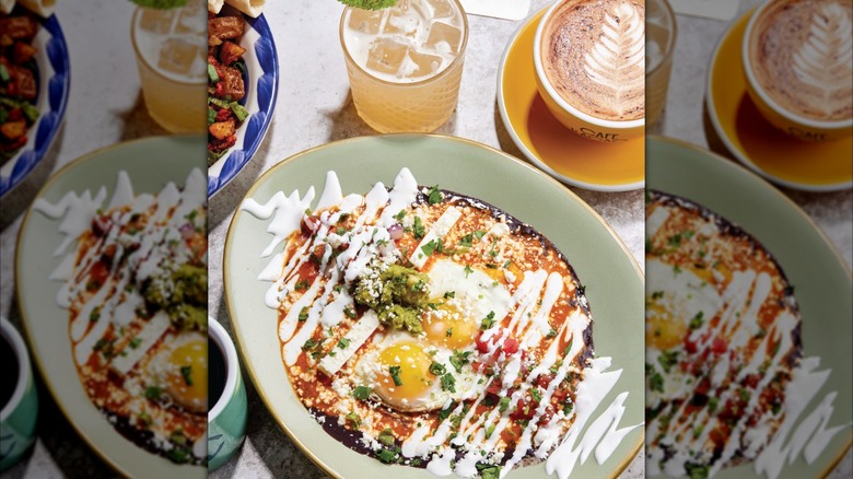 Breakfast dishes with eggs, cocktail, and latte