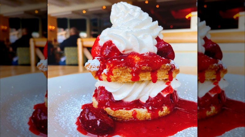 Tall stack of strawberry shortcake with layers of whipped cream
