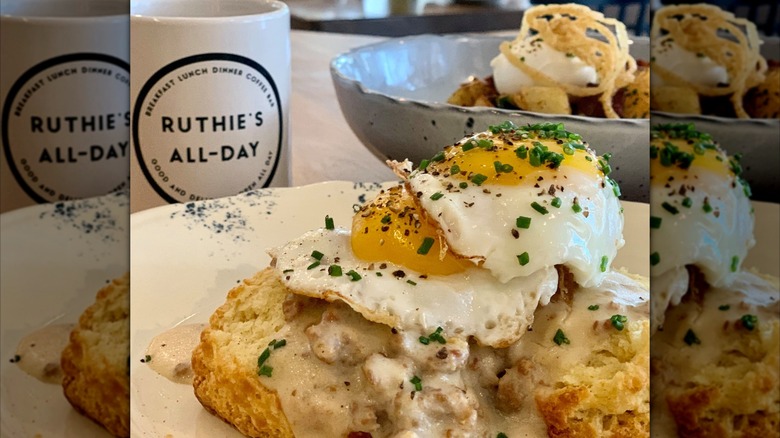 Biscuits and gravy with eggs on top and coffee mug in background
