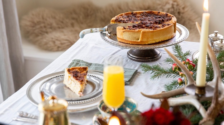 Table set for holiday brunch with quiche and slice on a plate