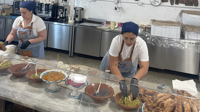 Two women man the cannoli station at I Segreti del Chiostro