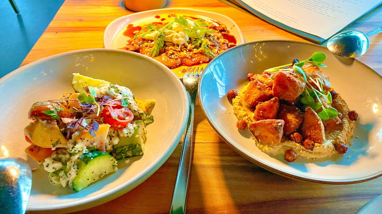 Fig carpaccio, tomato and peach salad, and fried sweet potatoes with hummus and tahini at Conifer in Bentonville