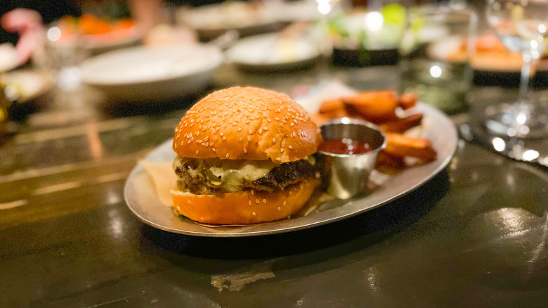 Cheeseburger on a sesame seed bun, with fries and ketchup at The Charter Oak Restaurant