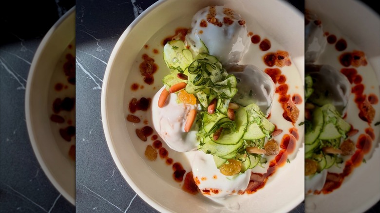 Lamb kheema-filled fried dumplings in savory yogurt sauce with mint, cucumber, and chili crisp at Of Course Kitchen & Company