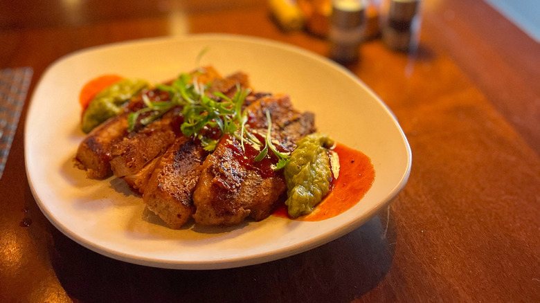 Thick-cut pork belly with guacamole and red chile sauce at Terra restaurant