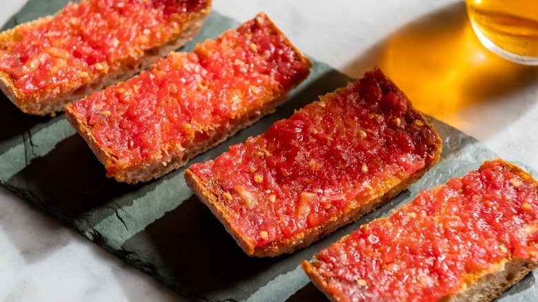 Pan con tomate served on a elongated black plate at Cúrate Bar de Tapas