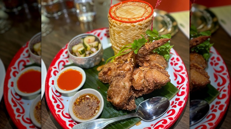 Hatyai Thai fried chicken with five-spice garlic marinade, cilantro, sticky rice, cucumber salad, chili sauce, and nam jim jaeow