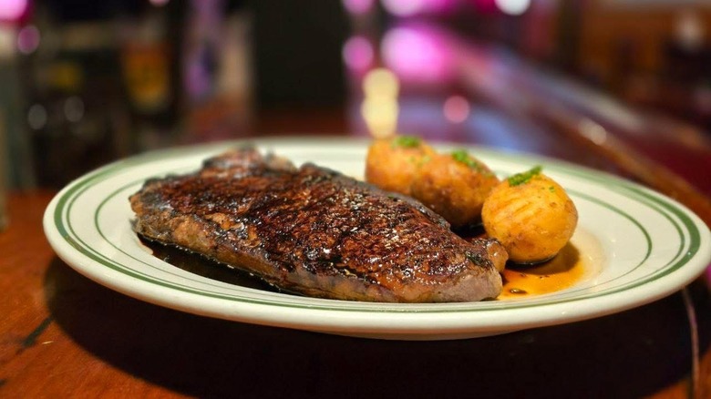 Steak served with butter and potatoes at Five O'Clock Steakhouse