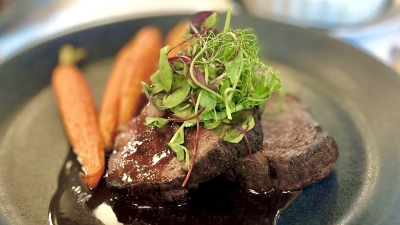 Herb-roasted rib-eye with carrots and herbs served at Le Rêve Restaurant & Raw Bar
