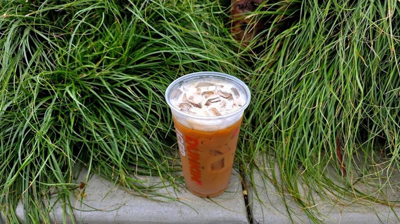 Dunkin's Brown Sugar Shakin' Espresso on curb next to grass