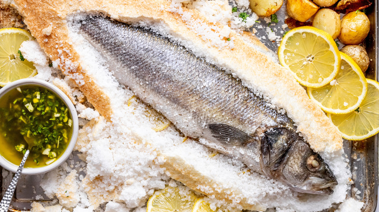 salt-baked sea bass on sheet pan with lemons, potatoes, and herb sauce