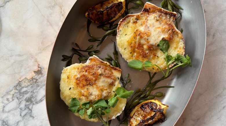 Seared scallops on metal serving tray with charred citrus
