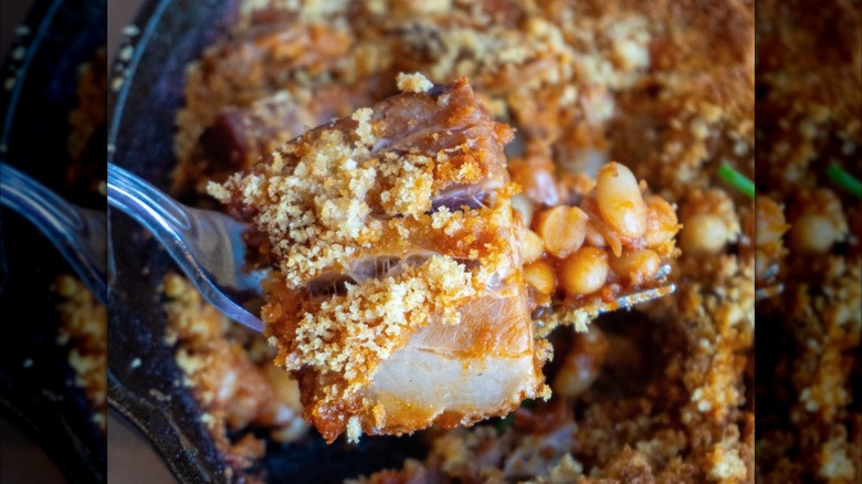 Forkful of cassoulet with serving blurred in background
