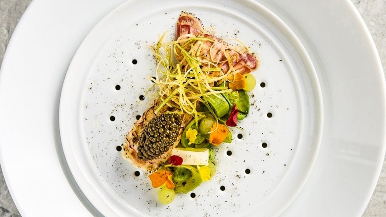 Langoustine and Osetra Caviar, apple, leek and avocado on white plate