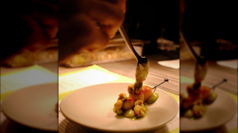 Scallops being garnished with caviar