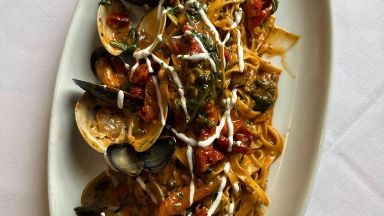 Mussels with pasta and white sauce drizzle