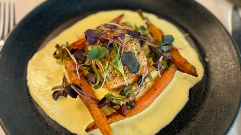 Salmon with greens, roasted carrots, and white sauce