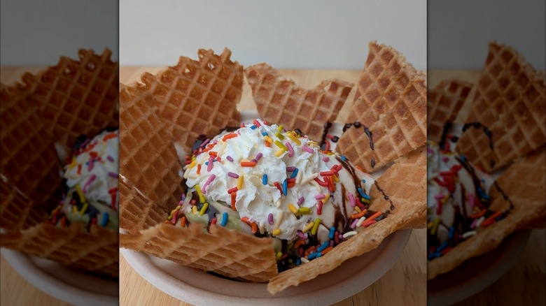 Waffle chips surrounding an ice cream sundae topped with sprinkles and hot fudge