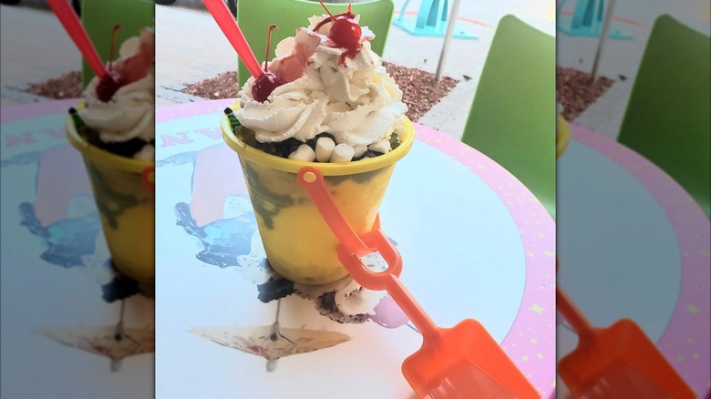 Ice cream sundae in a plastic beach pail with a shovel
