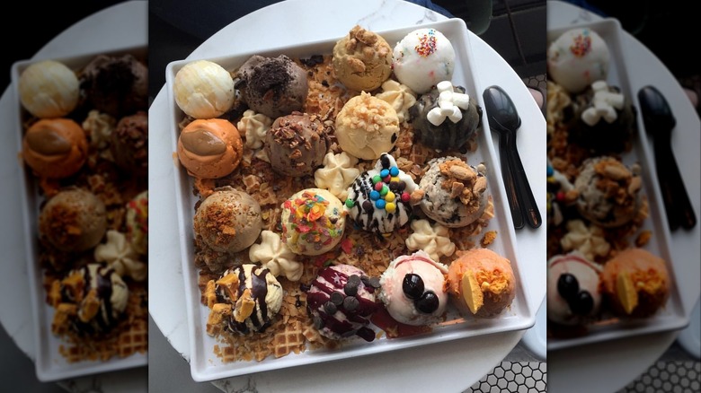 All of them sundae with 16 scoops of ice cream and toppings on plate