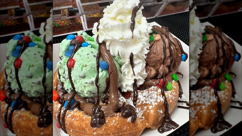 Waffle topped with ice cream, M&Ms, whipped cream, and chocolate syrup