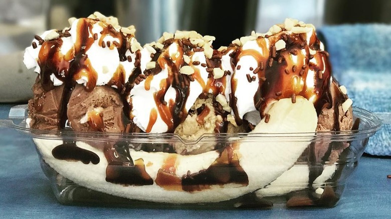 Side view of banana split in plastic takeout container
