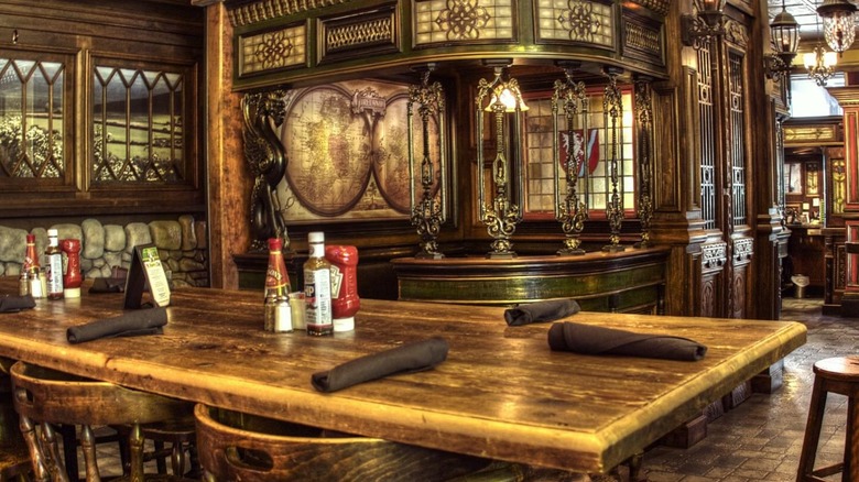 Victorian-designed pub interior with table, chairs, and stained glass