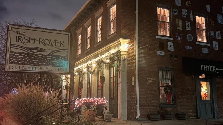 Exterior of The Irish Rover brick building at night with lights