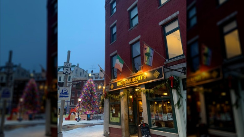 Exterior of brick building at night with snowy background