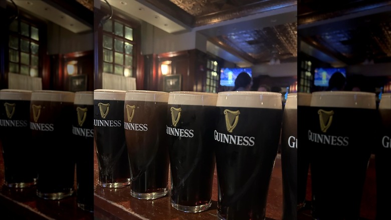 Row of Guinness pints with bar in background