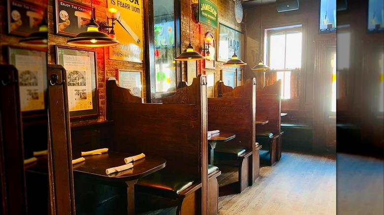 High-backed wooden booths with beer signs on the wall
