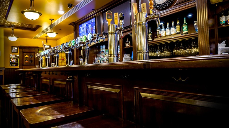 Low-angle shot of bar with lots of taps and stools