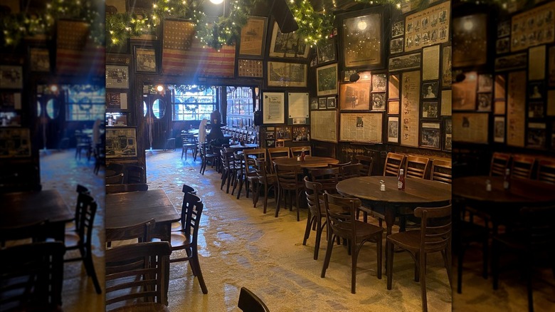 Tables and chairs at McSorley's with sawdust floor and bright lights